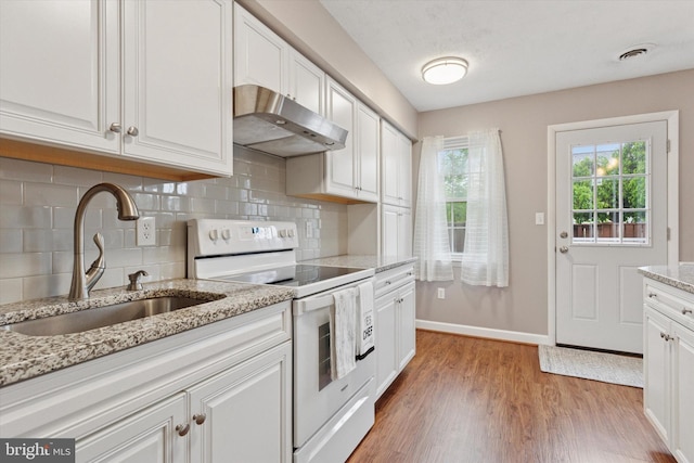 kitchen with white range with electric stovetop, a sink, under cabinet range hood, decorative backsplash, and light wood-style floors