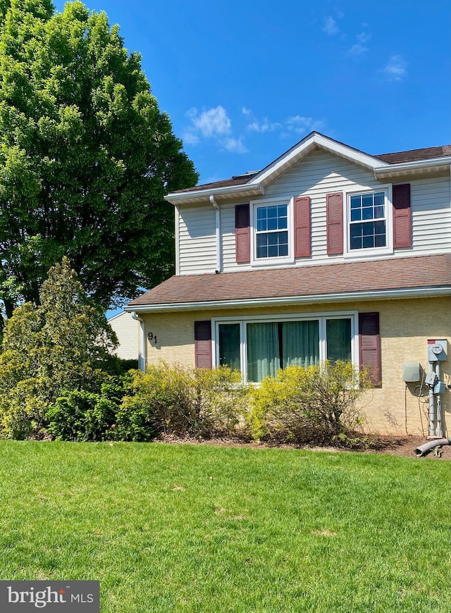 view of home's exterior with a lawn and a shingled roof
