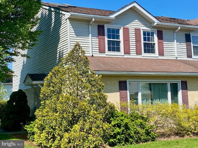 view of property exterior with roof with shingles