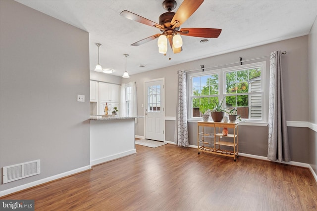 living room featuring wood finished floors, baseboards, and a ceiling fan