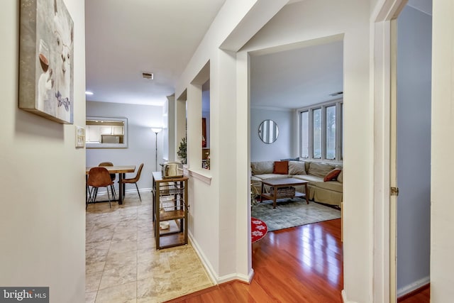 hall featuring wood finished floors and baseboards