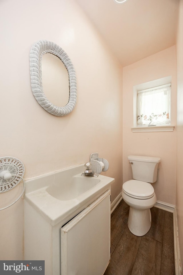 bathroom featuring vanity, toilet, wood finished floors, and baseboards