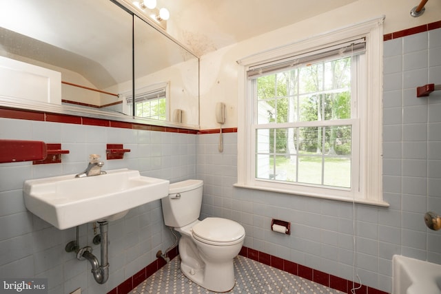 bathroom featuring tile walls, toilet, healthy amount of natural light, and tile patterned floors