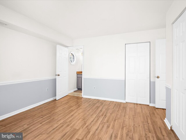 206 Water Fountain Ct Unit 201, Glen Burnie, MD 21060 - unfurnished bedroom featuring light wood-style floors, a closet, baseboards, and ensuite bathroom