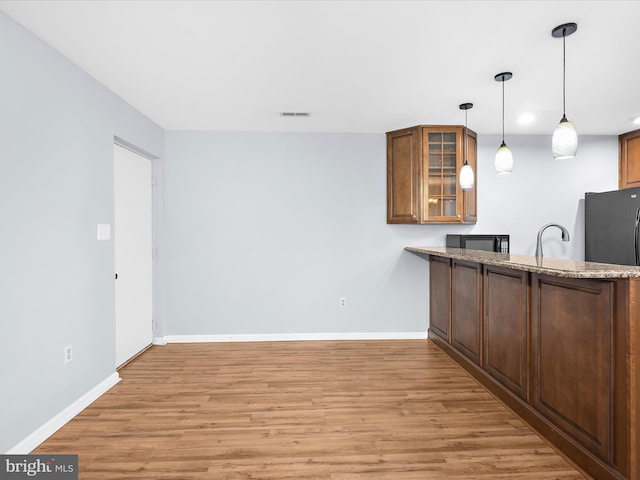 206 Water Fountain Ct Unit 201, Glen Burnie, MD 21060 - bar area with black microwave, light wood finished floors, baseboards, and hanging light fixtures