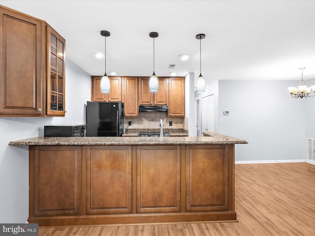 206 Water Fountain Ct Unit 201, Glen Burnie, MD 21060 - kitchen featuring black appliances, under cabinet range hood, stone counters, light wood-style flooring, and tasteful backsplash