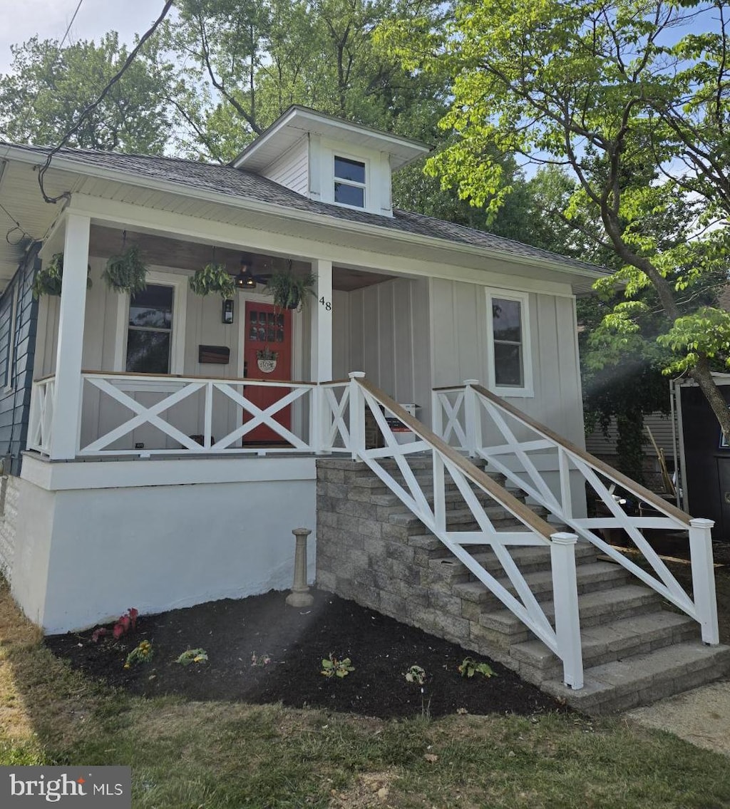 bungalow featuring a porch, board and batten siding, and roof with shingles