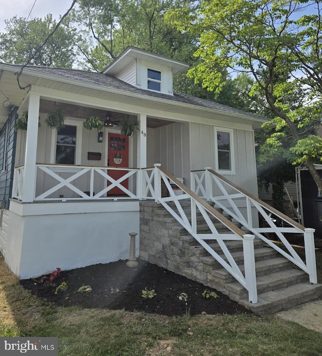 bungalow featuring a porch, board and batten siding, and roof with shingles