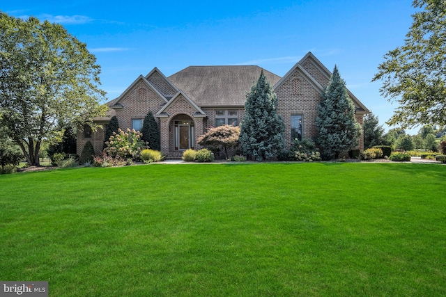 view of front of property with brick siding and a front yard