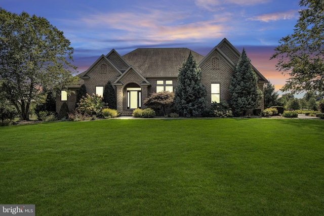 view of front of house featuring a front lawn and brick siding