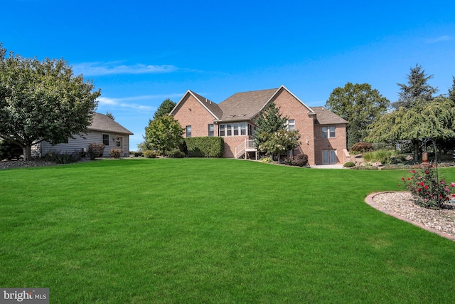 view of front facade featuring a front yard and brick siding