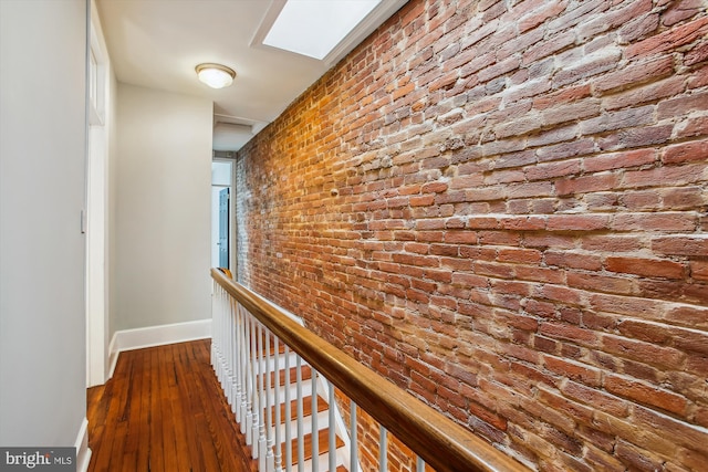 1314 Wallach Pl NW, Washington, DC 20009 - hall featuring brick wall, baseboards, wood-type flooring, and an upstairs landing