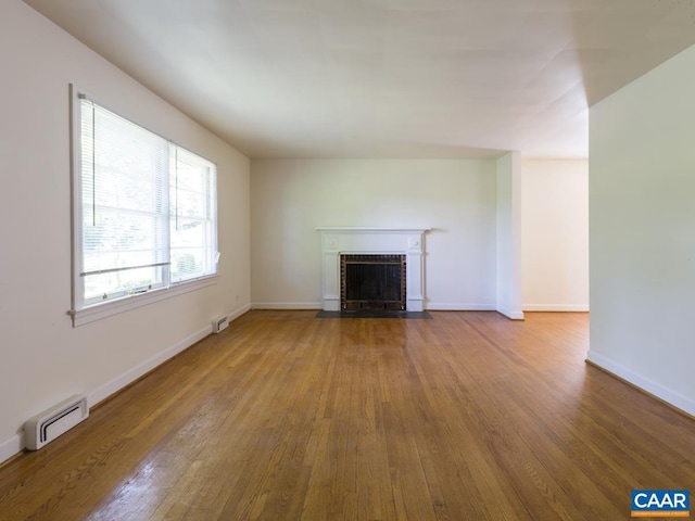 821 Cabell Ave Unit A & B, Charlottesville, VA 22903 - unfurnished living room with wood finished floors, a brick fireplace, and baseboards