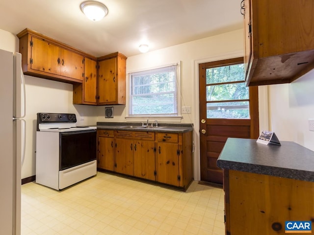 821 Cabell Ave Unit A & B, Charlottesville, VA 22903 - kitchen with white appliances, dark countertops, brown cabinets, light flooring, and a sink