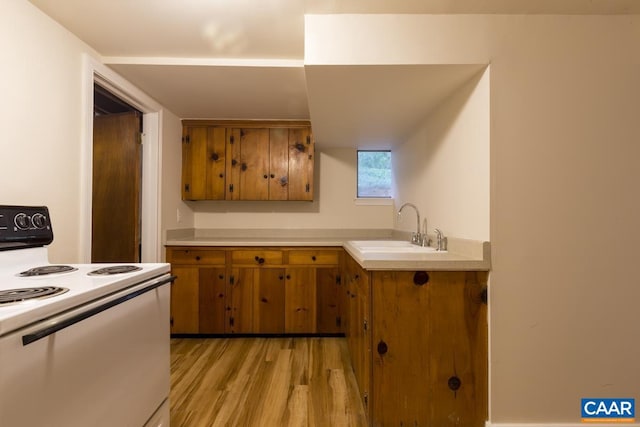 821 Cabell Ave Unit A & B, Charlottesville, VA 22903 - kitchen featuring white range with electric stovetop, brown cabinetry, a sink, light countertops, and light wood-style floors