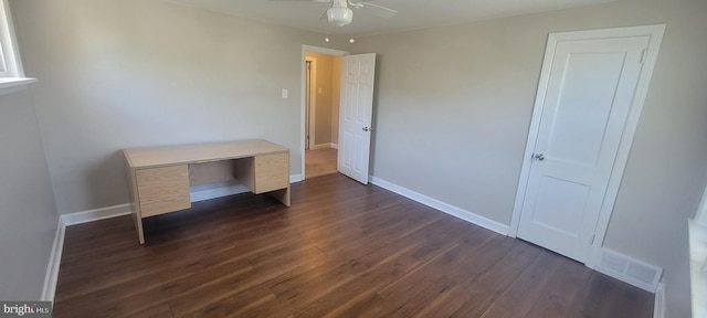 unfurnished office with a ceiling fan, dark wood finished floors, and baseboards