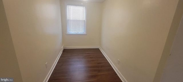 empty room with dark wood-style floors and baseboards