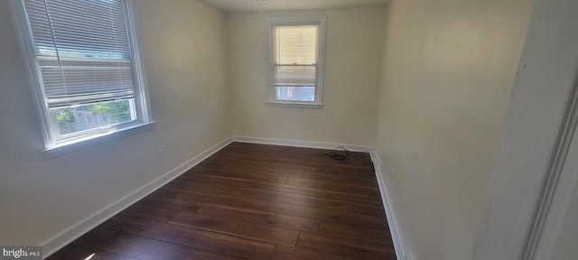 unfurnished room with dark wood-style floors and baseboards