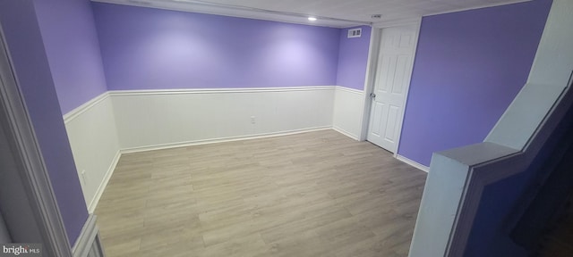 spare room featuring wood finished floors and wainscoting