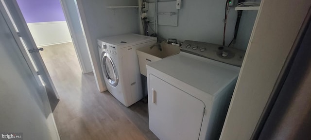 washroom featuring separate washer and dryer and light wood finished floors