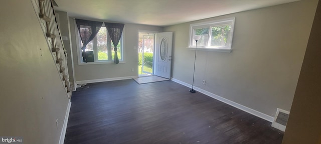 entrance foyer with plenty of natural light, dark wood-type flooring, and baseboards