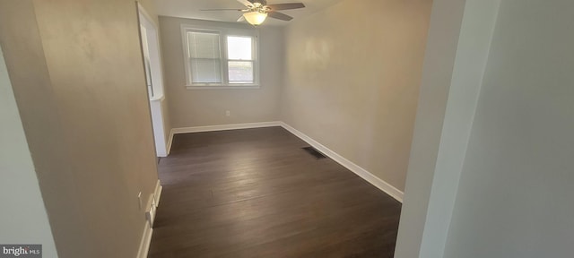 spare room featuring dark wood-style flooring, baseboards, and a ceiling fan