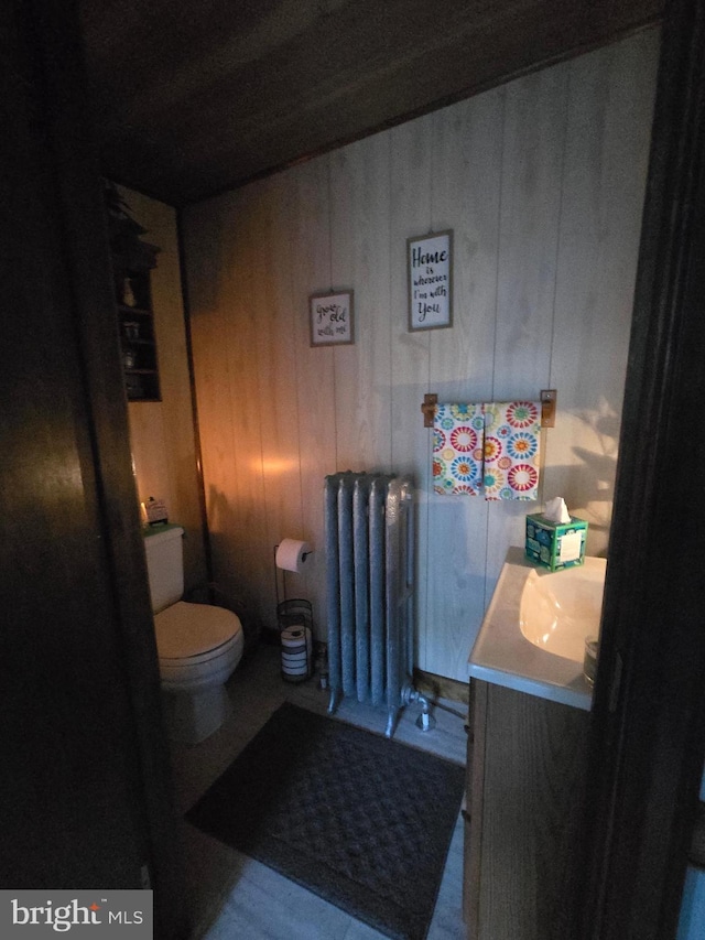 34E Reliance Rd, Souderton, PA 18964 - bathroom with radiator, toilet, vanity, and wood walls