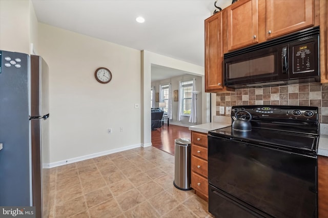 307 Obelisk Ln, Middletown, DE 19709 - kitchen with black appliances, decorative backsplash, brown cabinets, and light countertops