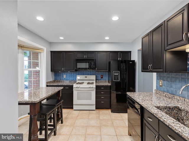 6521 Kemper Lakes Ct, Alexandria, VA 22312 - kitchen featuring black appliances, a sink, decorative backsplash, light stone countertops, and recessed lighting