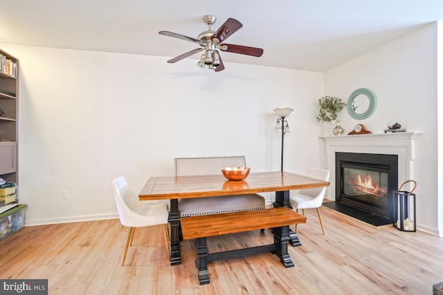 13304 Tivoli Fountain Ct, Germantown, MD 20874 - dining area with wood finished floors, ceiling fan, and a fireplace with flush hearth