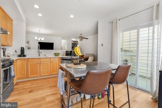 13304 Tivoli Fountain Ct, Germantown, MD 20874 - kitchen with stainless steel gas stove, a chandelier, light wood-type flooring, a peninsula, and recessed lighting