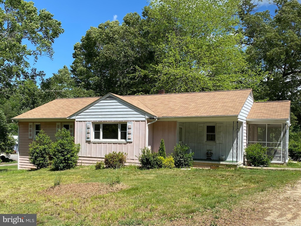 8690 Fairground Rd, Bel Alton, MD 20611 - ranch-style house with board and batten siding, a front yard, roof with shingles, and a sunroom