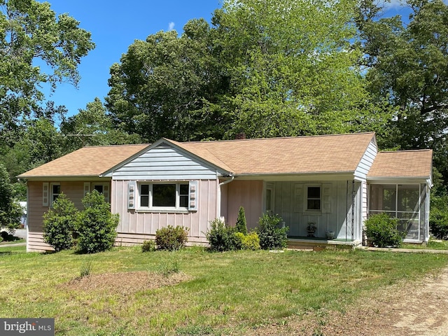 8690 Fairground Rd, Bel Alton, MD 20611 - ranch-style house with board and batten siding, a front yard, roof with shingles, and a sunroom