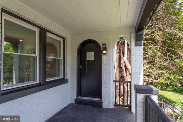 doorway to property with brick siding and a balcony