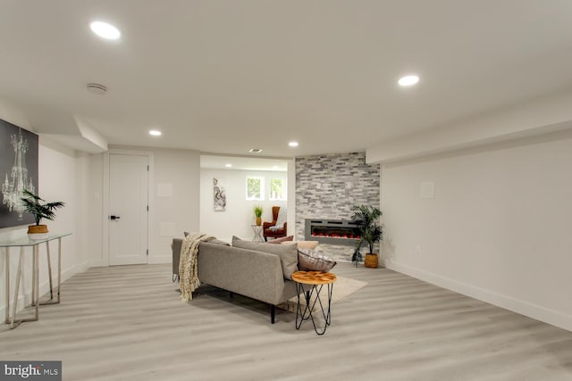 living area with light wood-type flooring, recessed lighting, a fireplace, and baseboards
