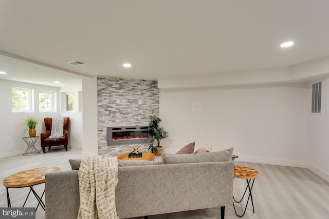 living area with a fireplace, recessed lighting, light wood-style floors, and baseboards