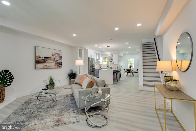 living area featuring stairway, recessed lighting, light wood-style flooring, and baseboards
