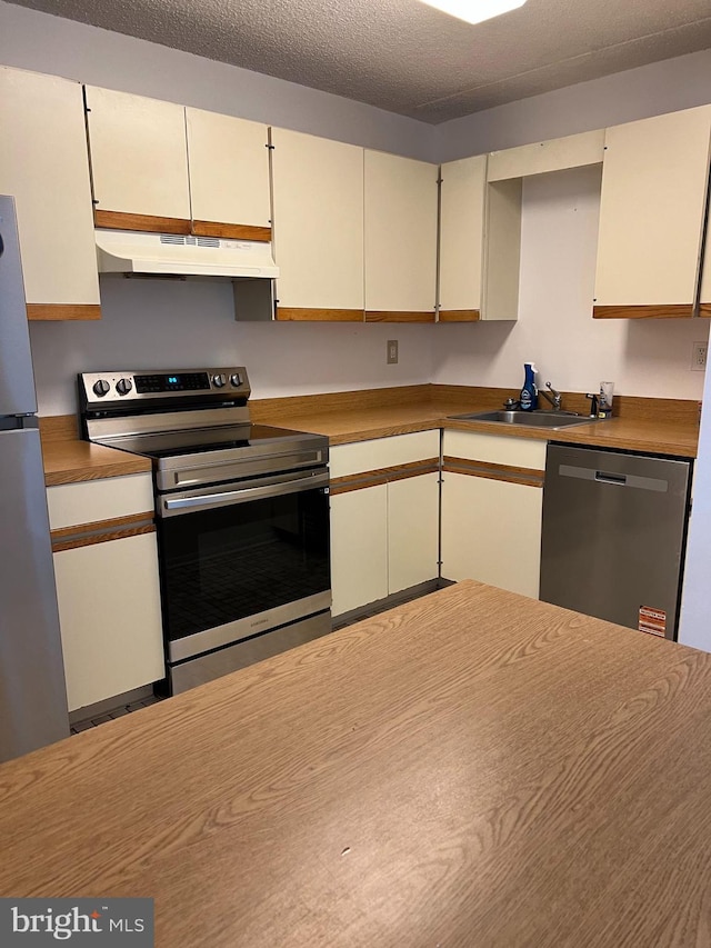 842 Putnam Blvd Unit 60A, Wallingford, PA 19086 - kitchen featuring appliances with stainless steel finishes, under cabinet range hood, a sink, and white cabinets