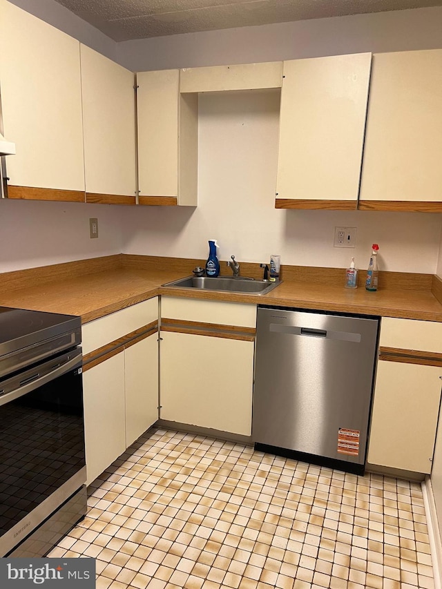 842 Putnam Blvd Unit 60A, Wallingford, PA 19086 - kitchen featuring appliances with stainless steel finishes, a sink, light tile patterned floors, and white cabinets