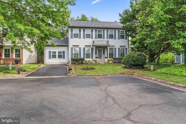 10103 Wimbledon Ct, Manassas, VA 20110 - colonial inspired home with driveway, a front yard, and a shingled roof