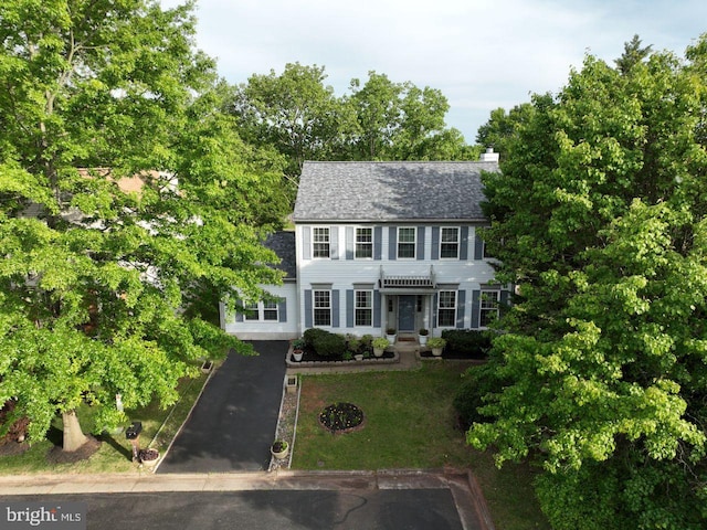 10103 Wimbledon Ct, Manassas, VA 20110 - colonial inspired home featuring driveway, a chimney, roof with shingles, and a front lawn