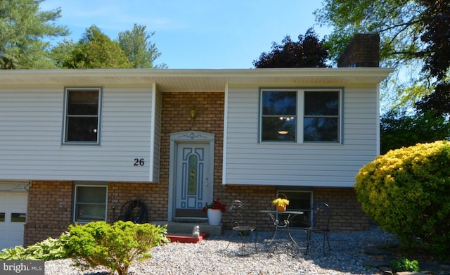 26 Shamrock Cir, Westminster, MD 21157 - split foyer home featuring brick siding, a garage, and a chimney