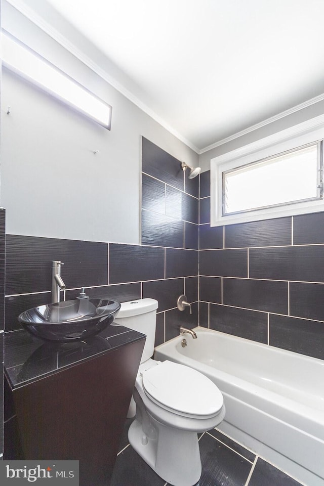 bathroom with tile walls, shower / bathtub combination, toilet, tile patterned floors, and vanity