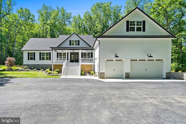5570 Warren Dr, Huntingtown, MD 20639 - view of front of house with stairway, ceiling fan, asphalt driveway, covered porch, and stone siding