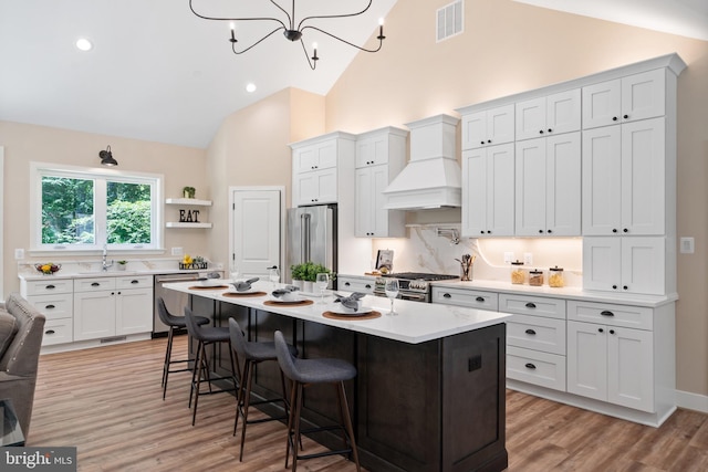 5570 Warren Dr, Huntingtown, MD 20639 - kitchen featuring premium range hood, premium appliances, light countertops, high vaulted ceiling, and a kitchen breakfast bar