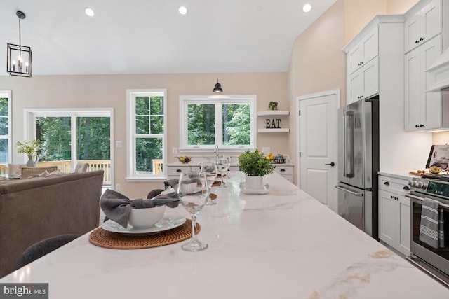 5570 Warren Dr, Huntingtown, MD 20639 - kitchen featuring premium appliances, open floor plan, light stone countertops, white cabinetry, and hanging light fixtures