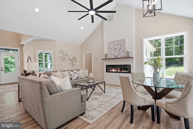 5570 Warren Dr, Huntingtown, MD 20639 - living area with high vaulted ceiling, plenty of natural light, wood finished floors, a large fireplace, and a chandelier