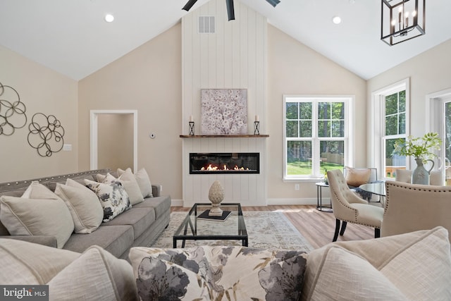 5570 Warren Dr, Huntingtown, MD 20639 - living room featuring high vaulted ceiling, plenty of natural light, wood finished floors, baseboards, and a large fireplace