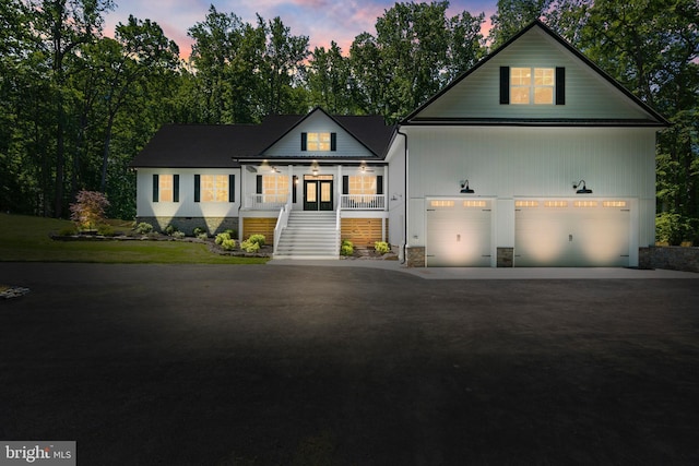 5570 Warren Dr, Huntingtown, MD 20639 - view of front of home featuring covered porch, stairway, driveway, and a garage