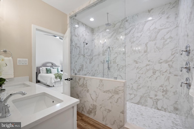 5570 Warren Dr, Huntingtown, MD 20639 - bathroom featuring wood finished floors, a marble finish shower, double vanity, and tile walls